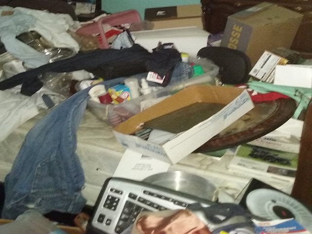 Cluttered bedroom before hoarding cleanup